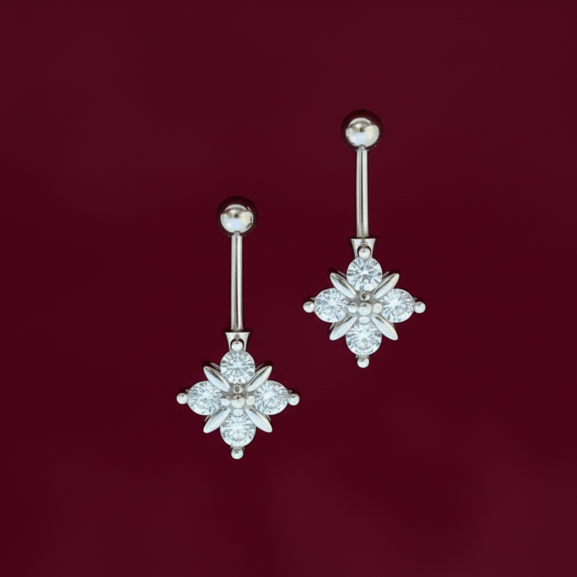 Pair of silver earrings with floral designs on a red background