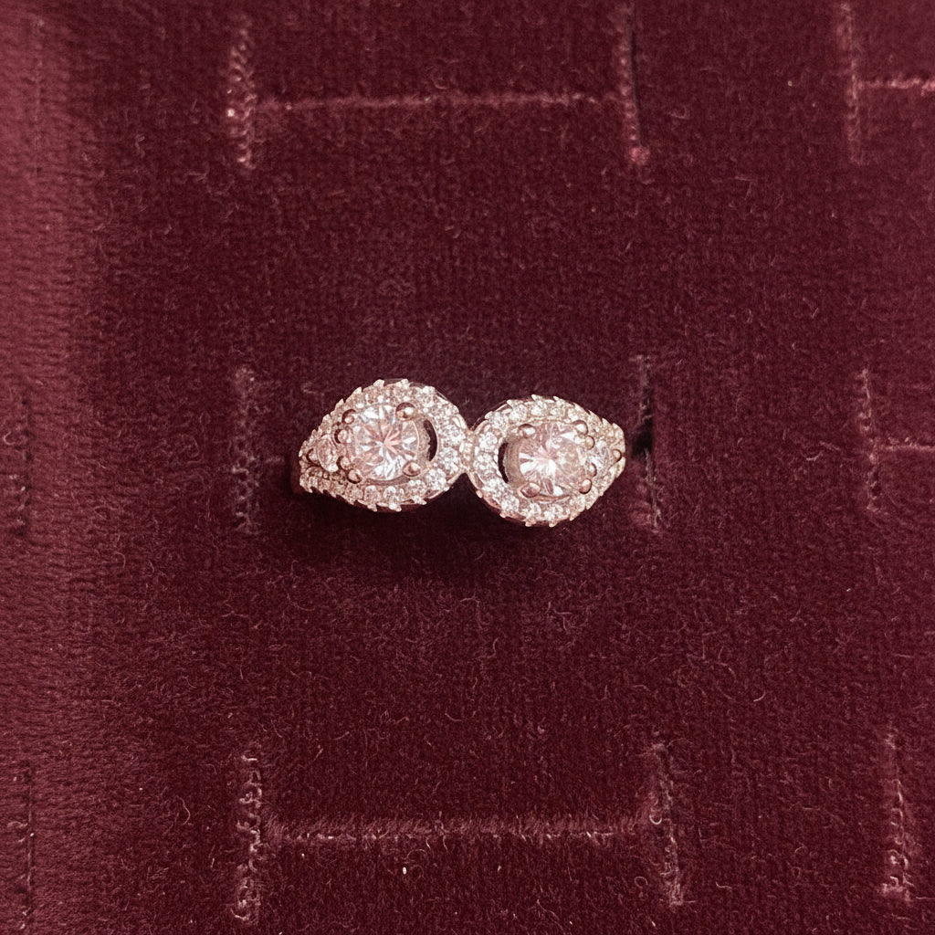 Pair of pink diamond earrings on a blue cushion