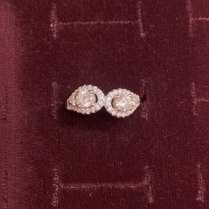Pair of pink diamond earrings on a blue cushion