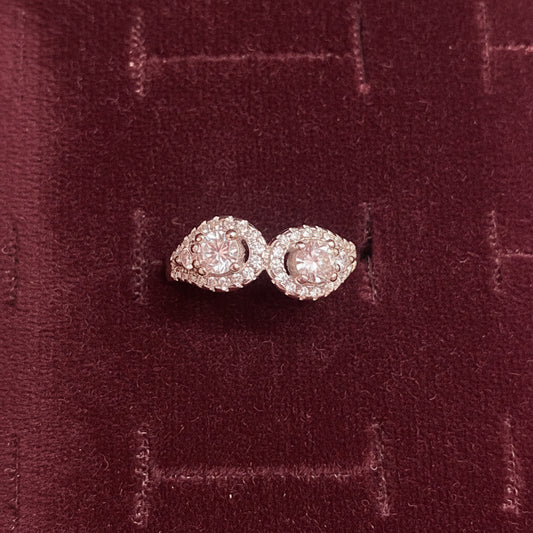 Pair of pink diamond earrings on a blue cushion