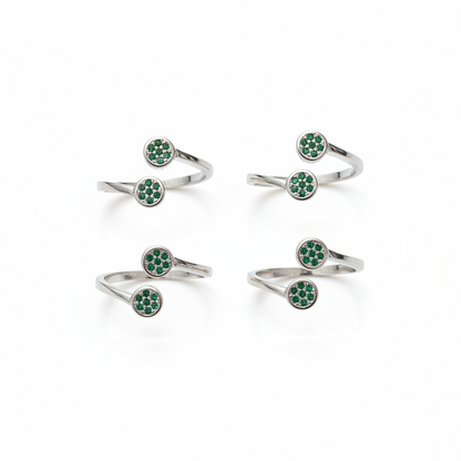 Set of silver rings with green gemstones on a white background