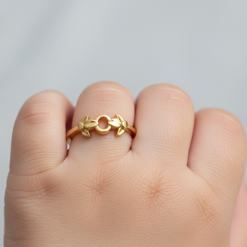Gold ring on a finger against a gray background