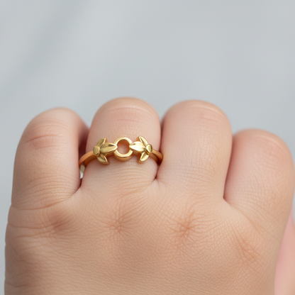 Gold ring on a finger against a gray background