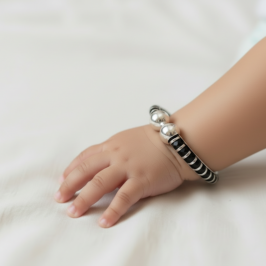 Child's hand wearing a bracelet on a white background