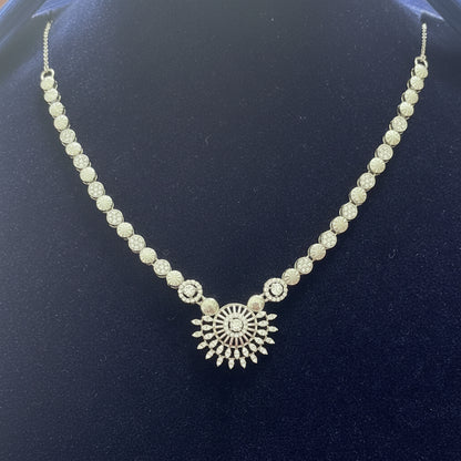 Silver necklace with a decorative clasp on a red velvet background