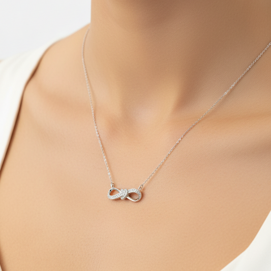 Silver necklace with a pendant in a black jewelry box on a red fabric background