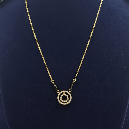 Gold necklace with a circular pendant on a red fabric background