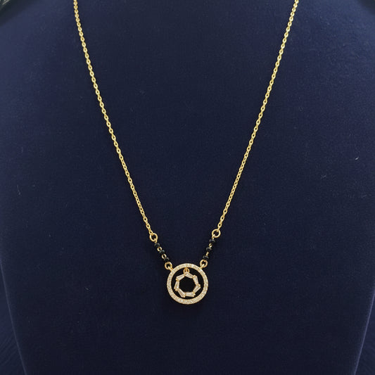 Gold necklace with a circular pendant on a red fabric background