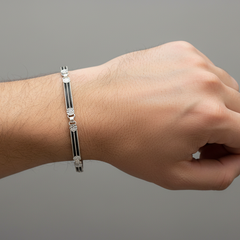 Hand wearing a silver bracelet on a gray background