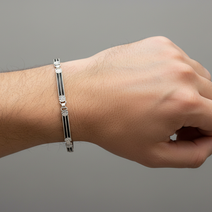 Hand wearing a silver bracelet on a gray background