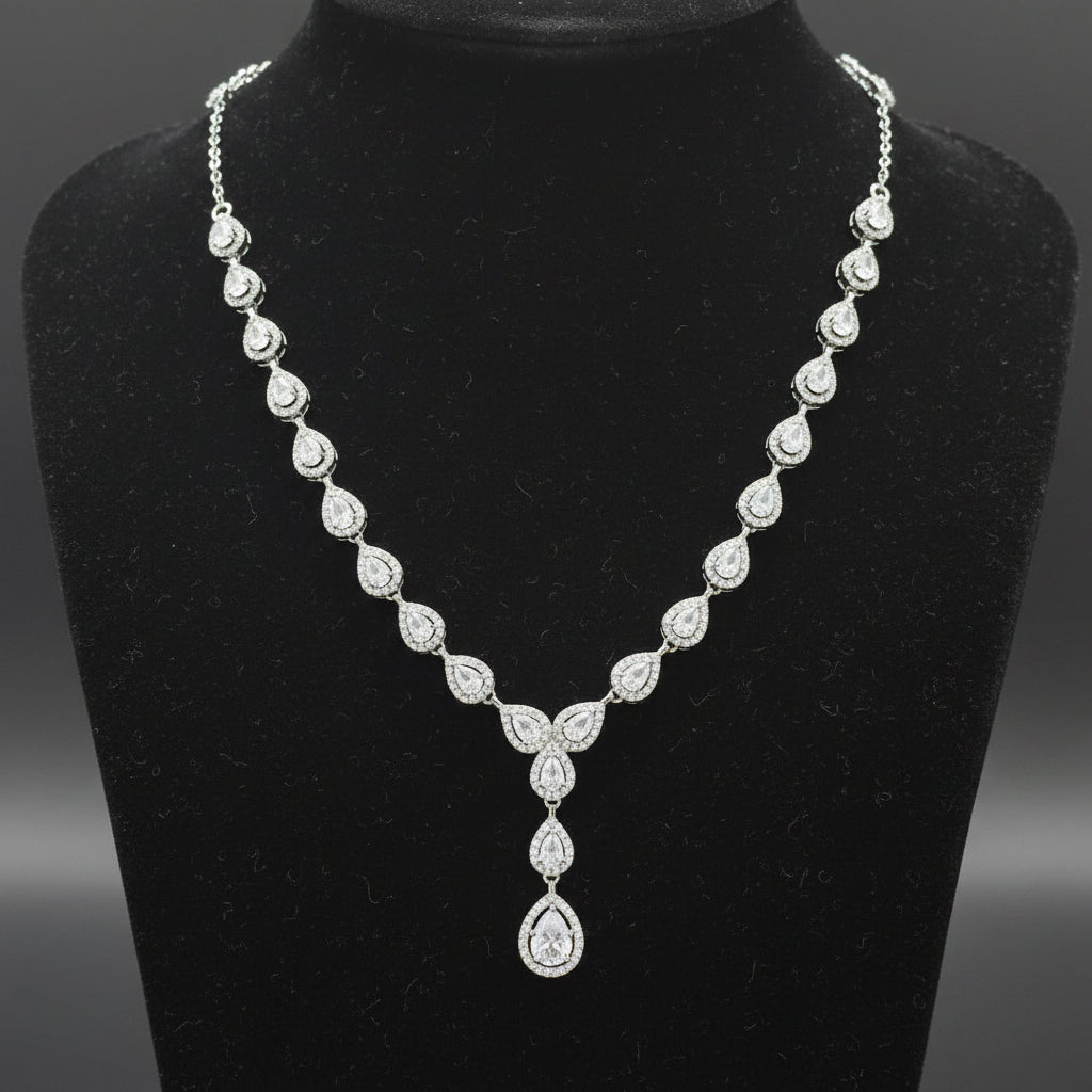 Silver necklace with a teardrop pendant on a red velvet background