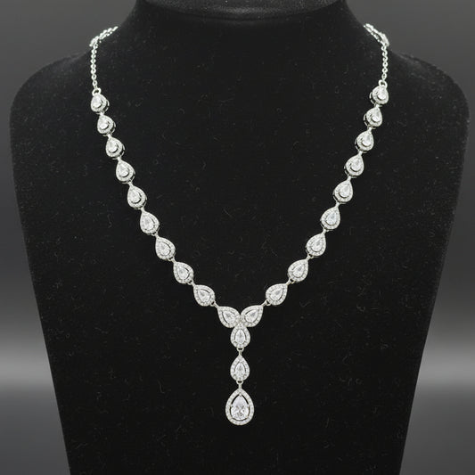 Silver necklace with a teardrop pendant on a red velvet background