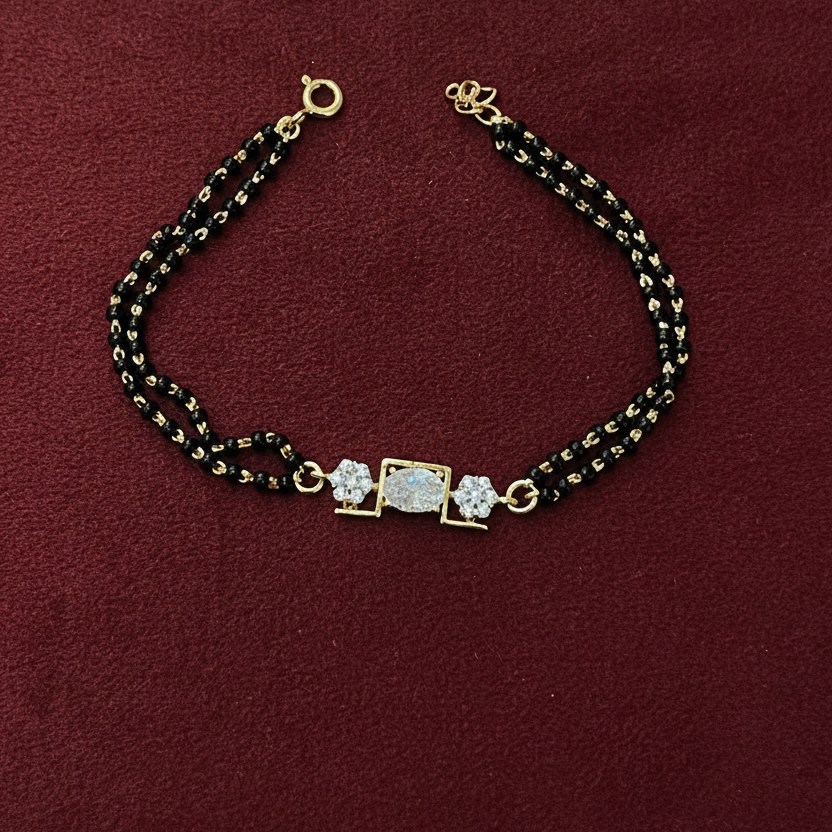 Bracelet with gold and black beads on a red fabric background