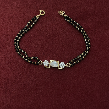 Bracelet with gold and black beads on a red fabric background