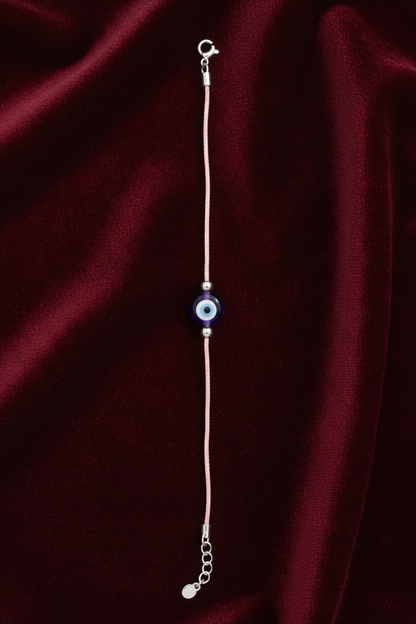bracelet with a blue evil eye pendant on a white background