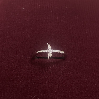 Ring with a cross design on a textured blue fabric background