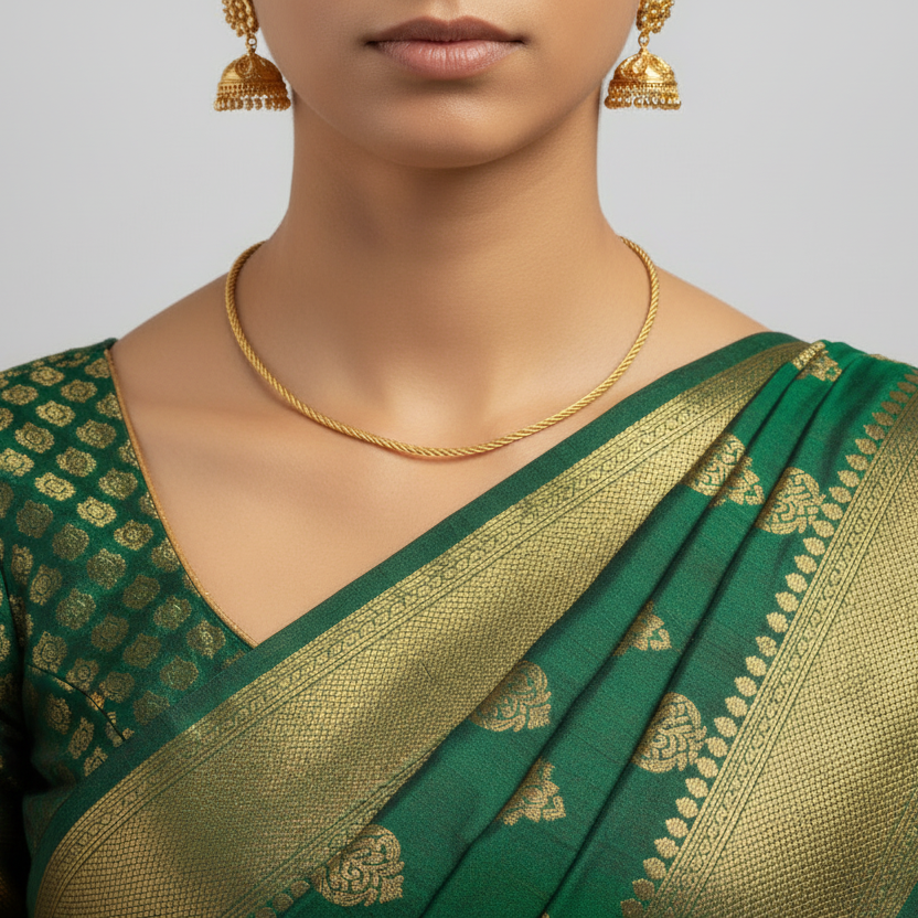 Woman wearing a green and gold saree with matching jewelry on a gray background
