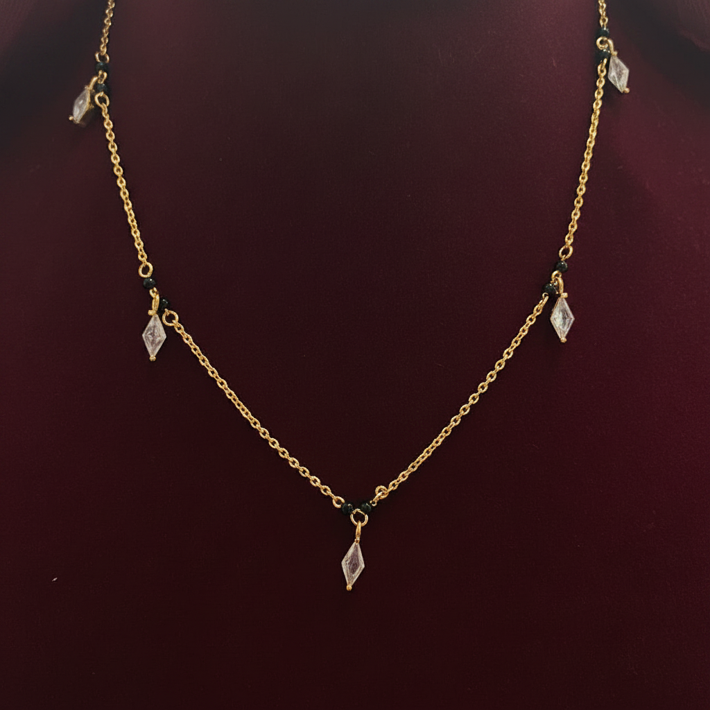Gold necklace with small pendants on a red fabric background