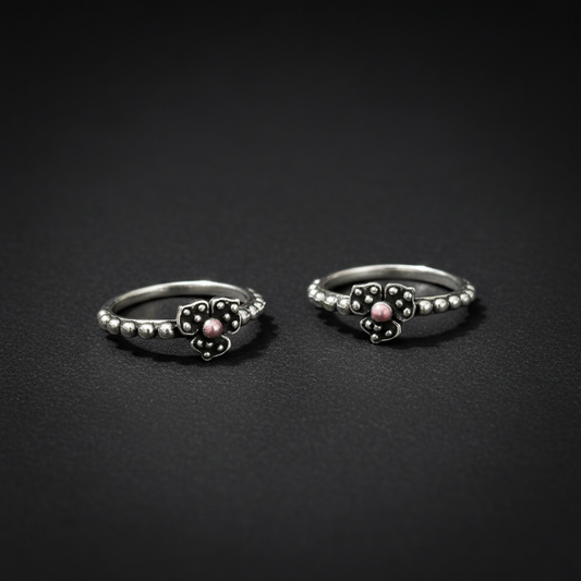 Silver earrings with marcasite stones on a pink textured background