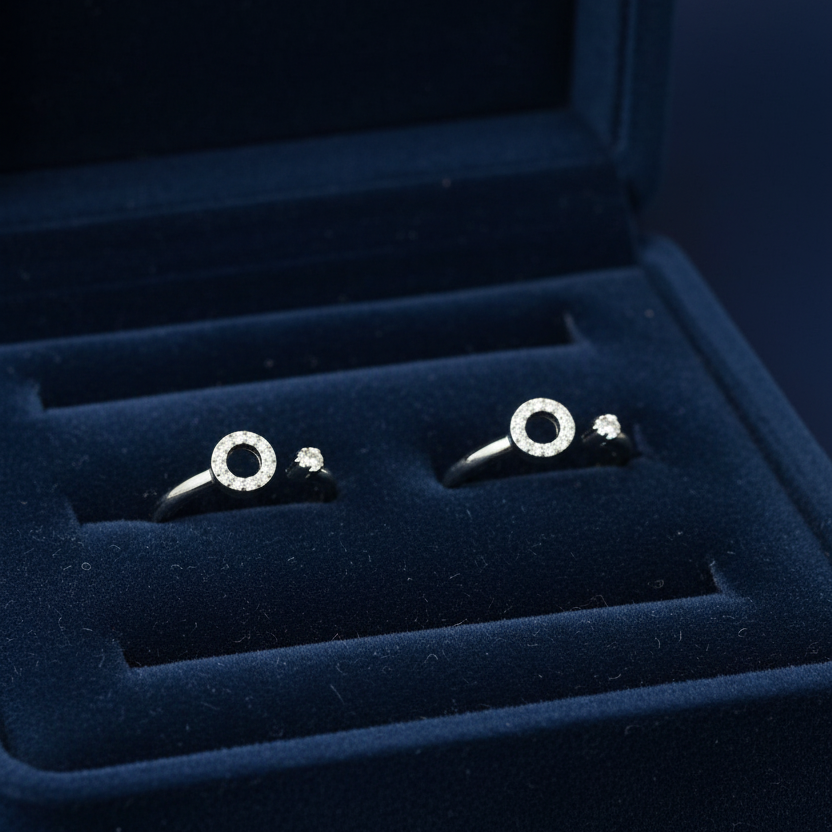 Silver earrings on a pink jewelry box with red fabric in the background