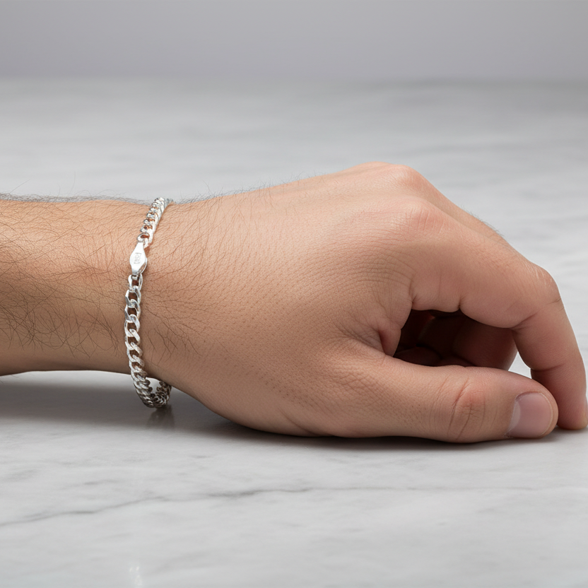 Hand wearing a silver bracelet on a light gray background