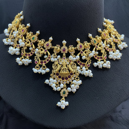 Gold necklace with pearls on a pink fabric background