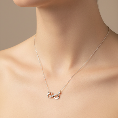 Silver necklace with a heart pendant in a gray box on a red fabric background