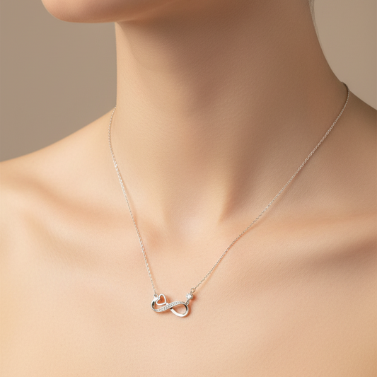 Silver necklace with a heart pendant in a gray box on a red fabric background