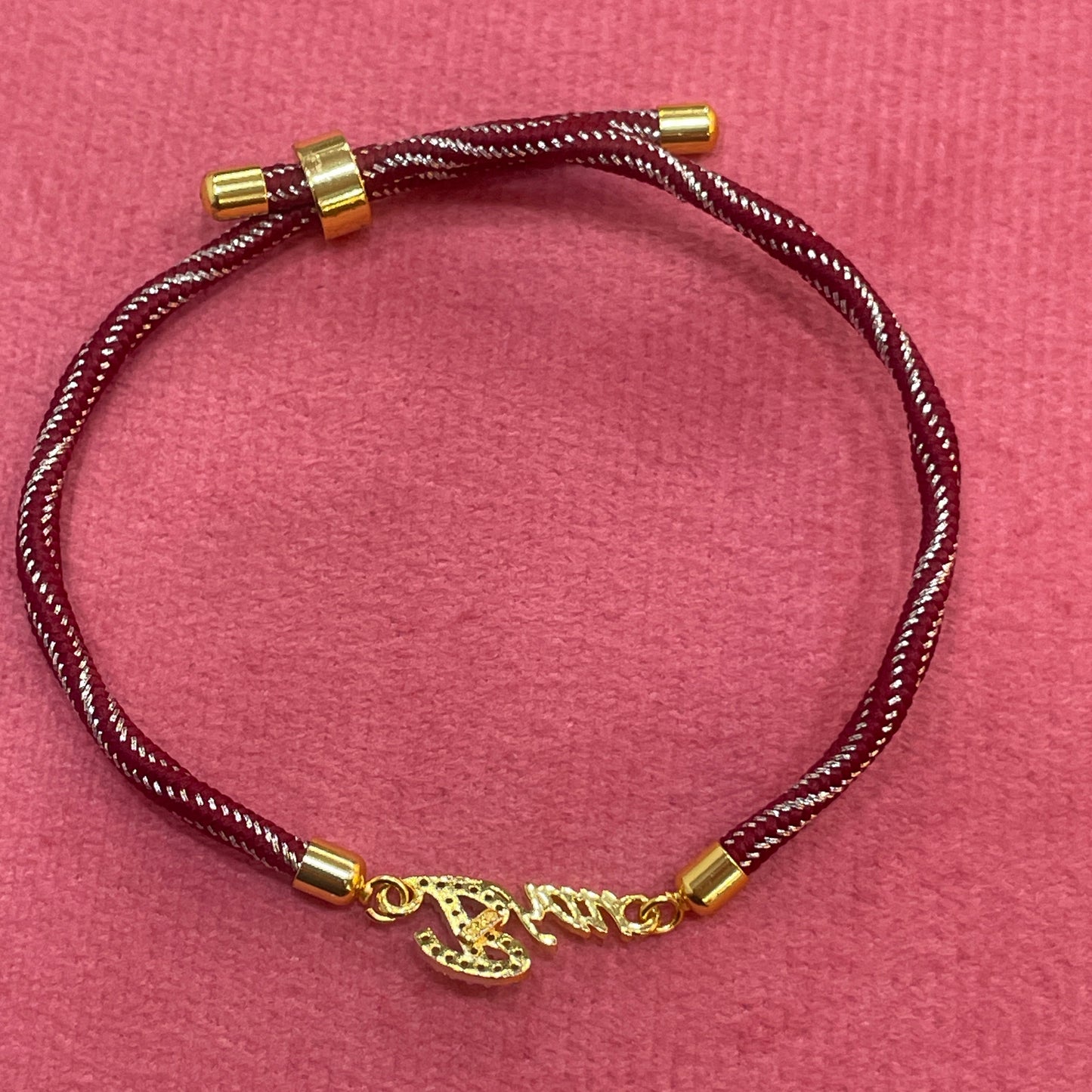 Gold-Plated Bhaiya Name Rakhi for Brother | CZ Script Charm on Maroon & Gold Twisted Thread