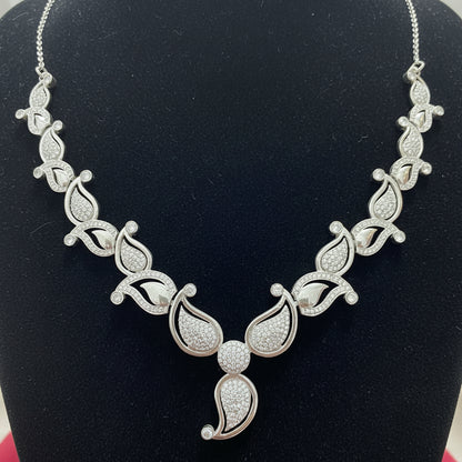 Silver necklace with intricate design on a red velvet background