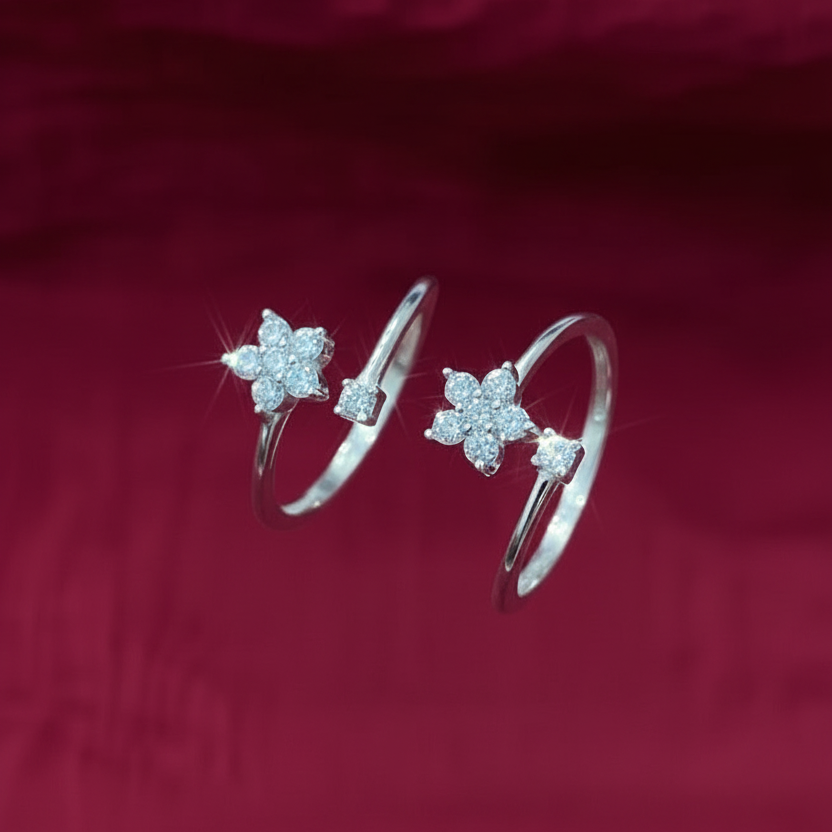 Close-up of a hand wearing two silver star-shaped rings on a red fabric background