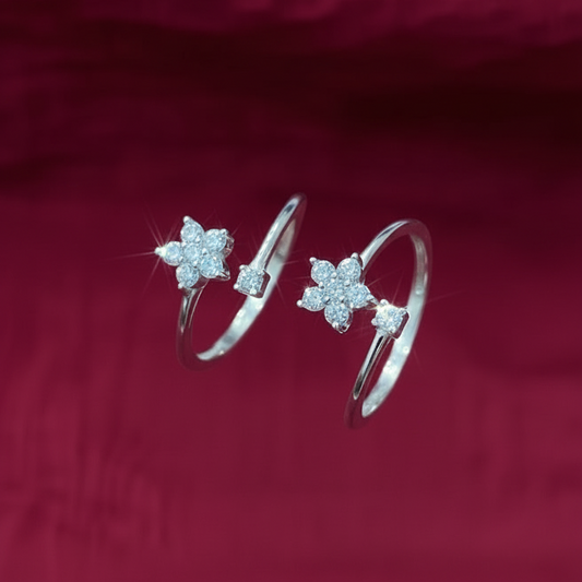 Close-up of a hand wearing two silver star-shaped rings on a red fabric background