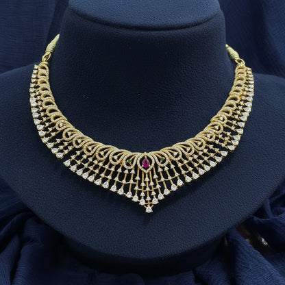Gold necklace with a red gemstone on a red fabric background