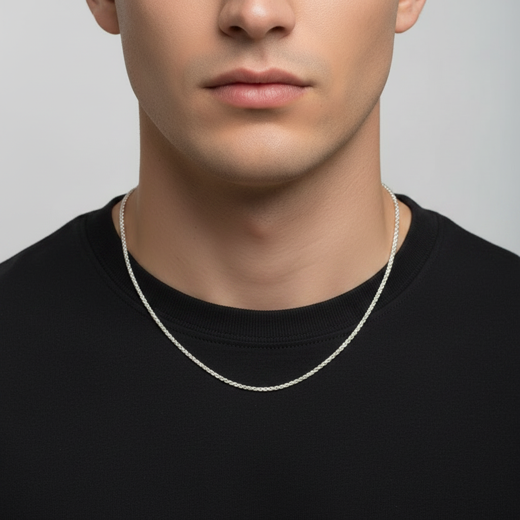 Man wearing a silver necklace against a plain background