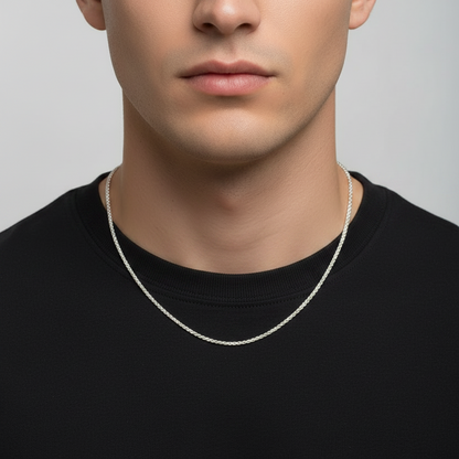 Man wearing a silver necklace against a plain background