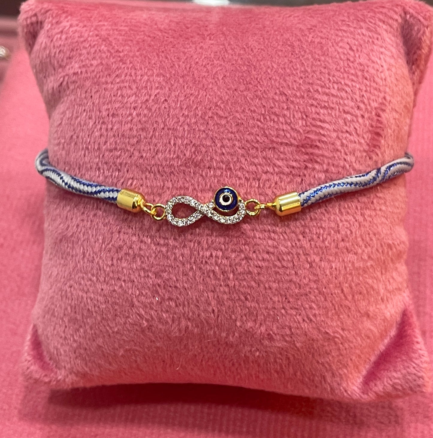 Gold-Plated Rakhi for Brother | CZ Infinity & Evil Eye Charm on Blue Silk Thread