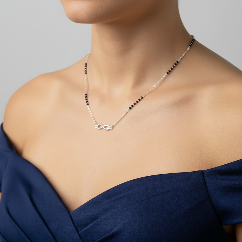 Person wearing a delicate necklace with a plain background