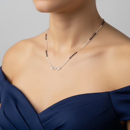 Person wearing a delicate necklace with a plain background
