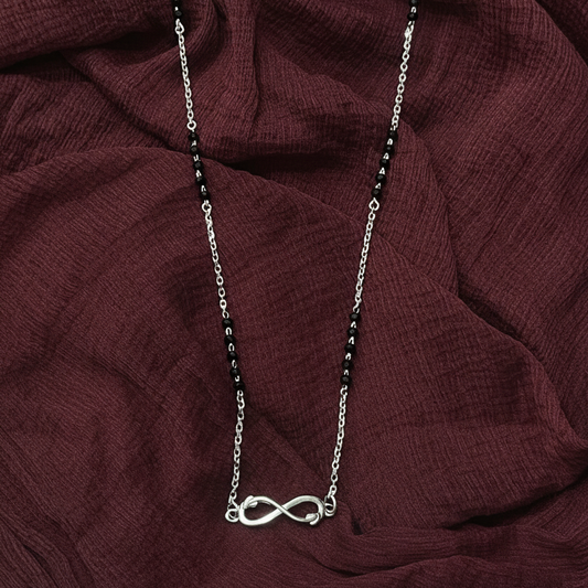 Necklace with an infinity symbol pendant on a red fabric background