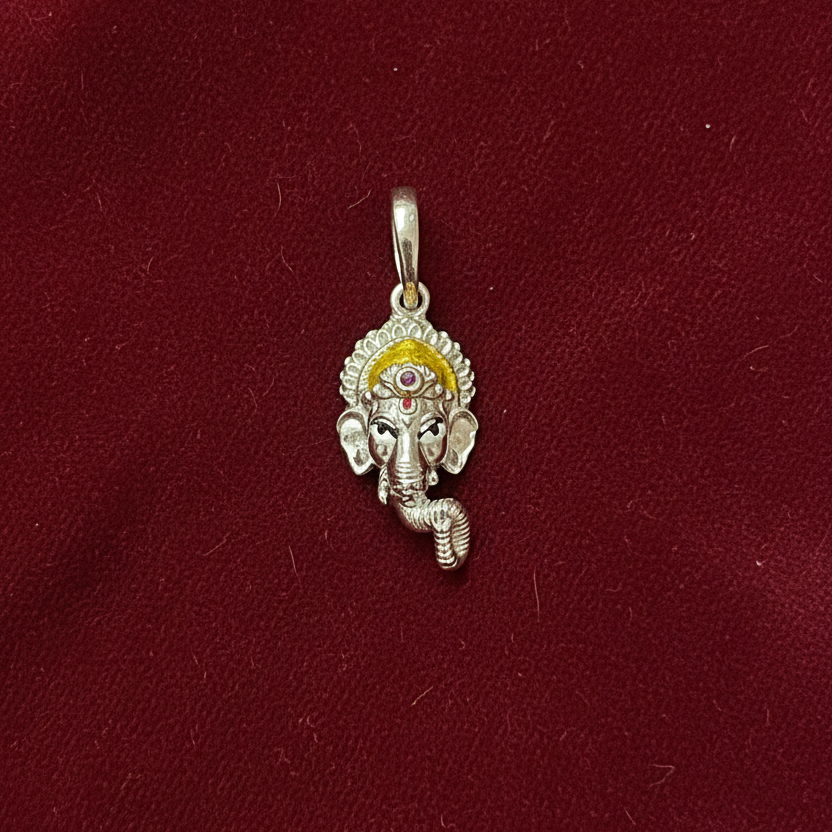 Silver pendant with a deity figure on a red fabric background