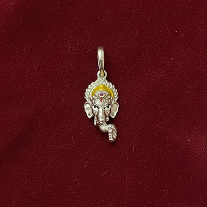 Silver pendant with a deity figure on a red fabric background