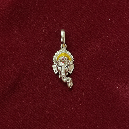 Silver pendant with a deity figure on a red fabric background