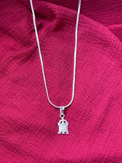 Silver necklace with a small pendant on a red fabric background