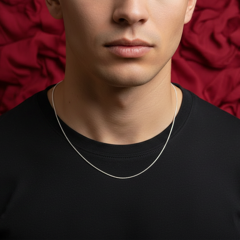 Man wearing a silver necklace against a red textured background