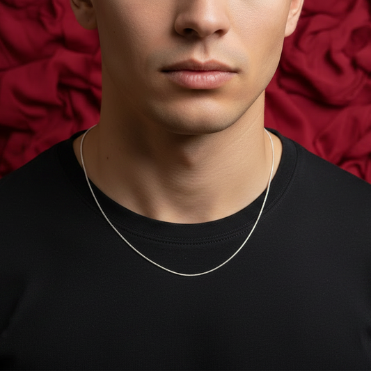 Man wearing a silver necklace against a red textured background