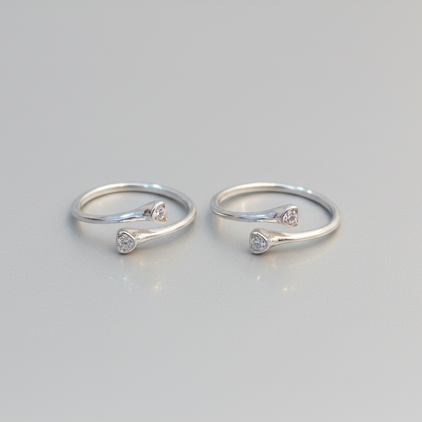 Two silver rings with small diamonds on a light gray background