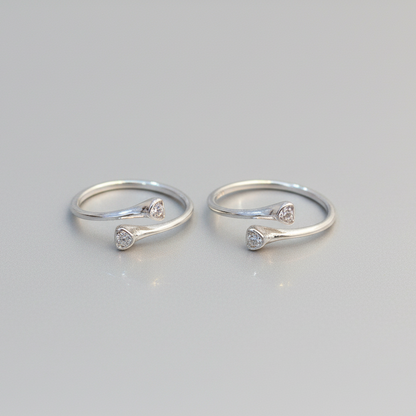Two silver rings with small diamonds on a light gray background