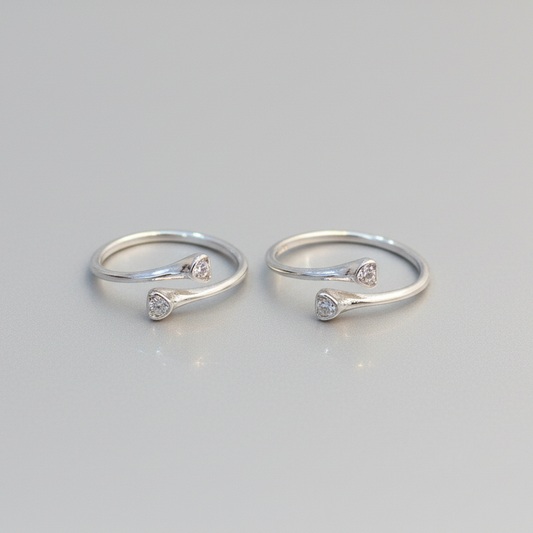 Two silver rings with small diamonds on a light gray background