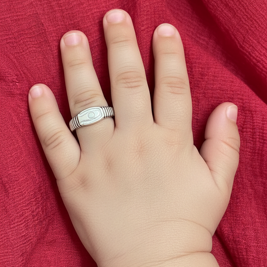 Hand wearing a silver ring on a red fabric background