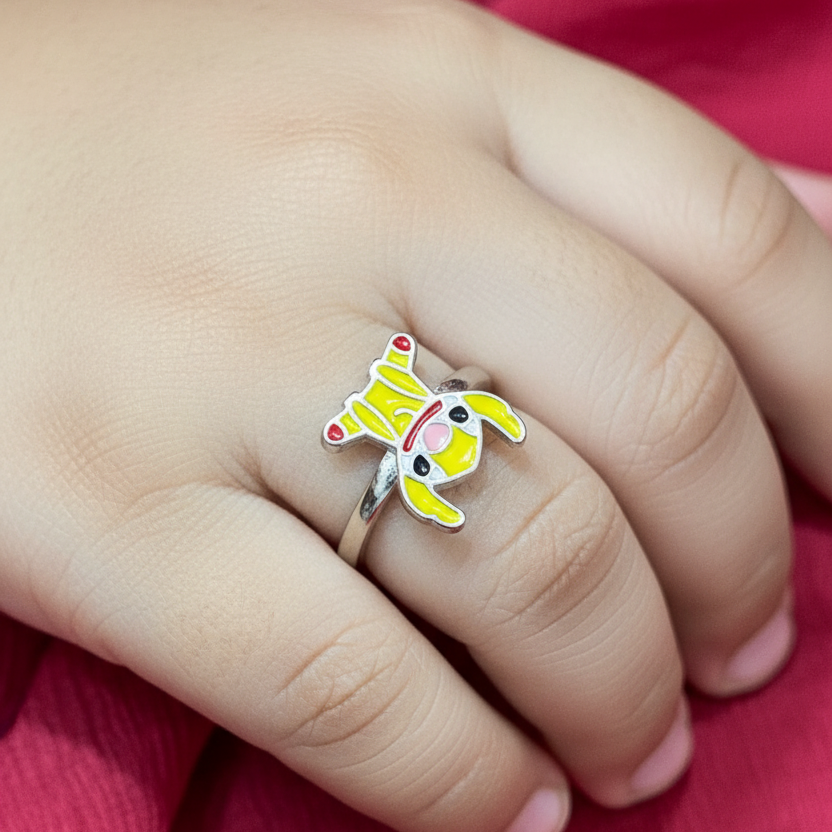 Child's hand wearing a cartoon character ring on a red fabric background